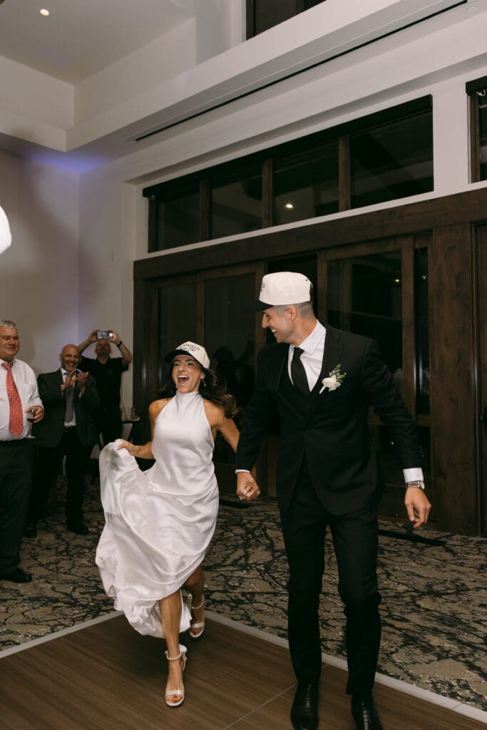 Natalie and Nick make their grand entrance into the reception wearing custom ball caps