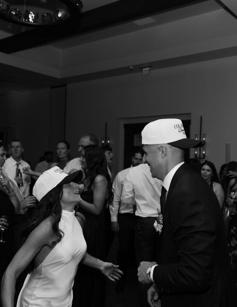 Bride and groom dancing in the crowd in black and white
