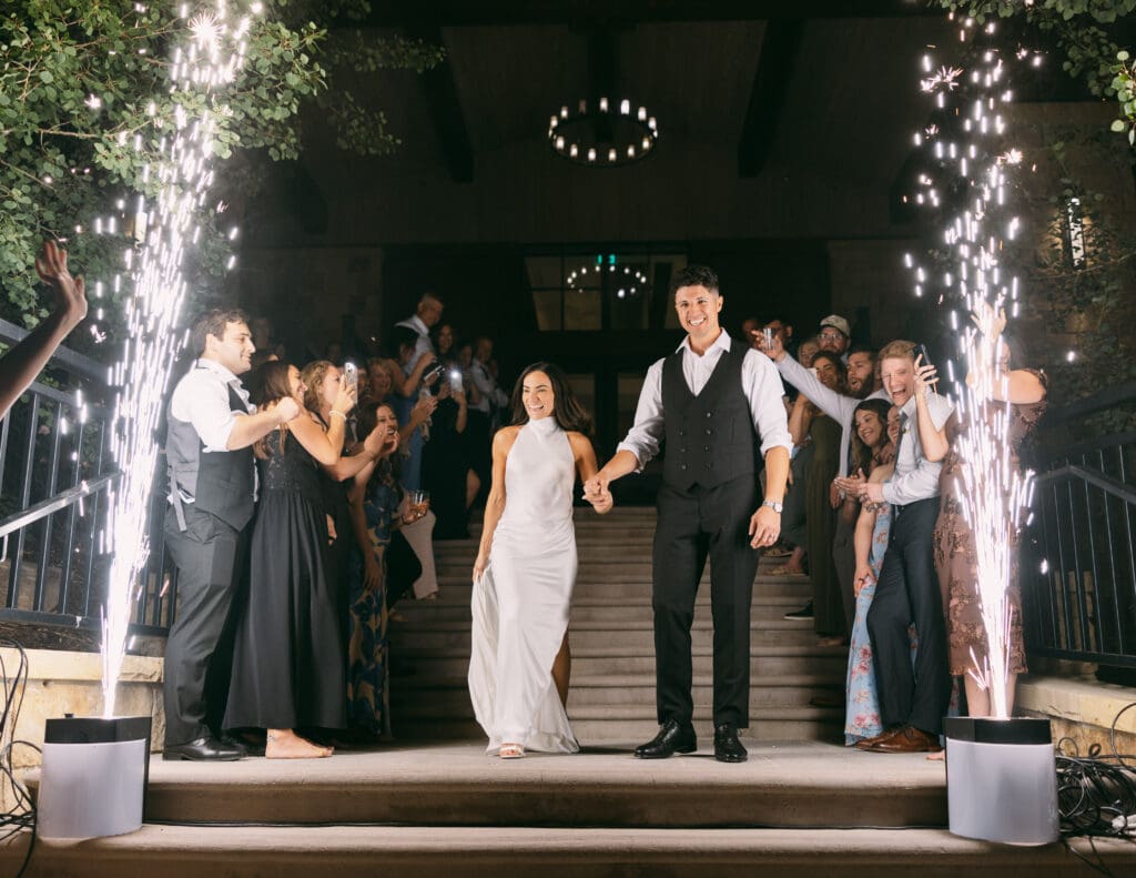 Natalie and Nick framed by cold sparkler fountains on the steps at TPC Colorado