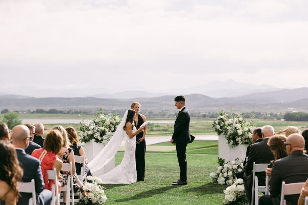 Natalie and Nick exchange vows during an outdoor lawn ceremony at TPC Colorado with mountain views