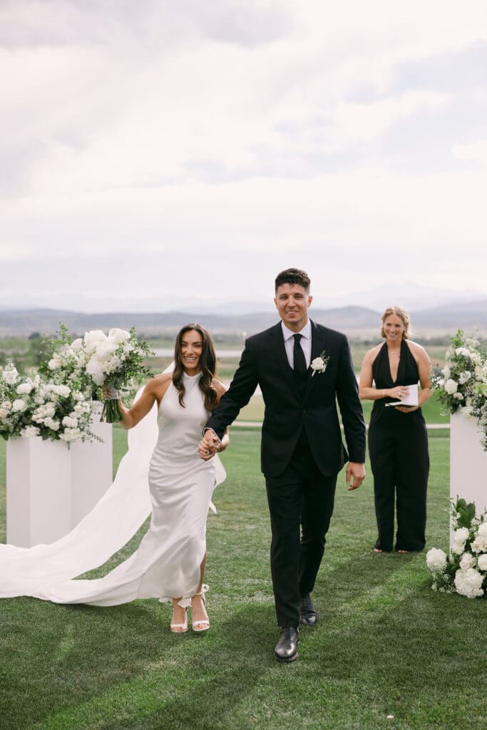 Natalie and Nick walk back up the aisle hand in hand after the ceremony