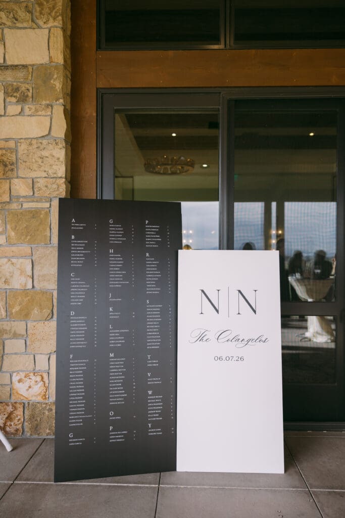 Monogram welcome sign and black seating chart at the reception entrance