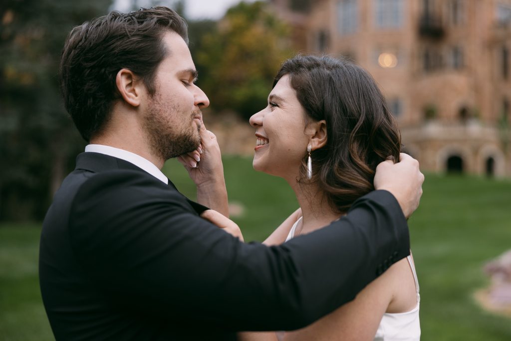 Bridgette laughs as she touches Logan's face on the castle grounds