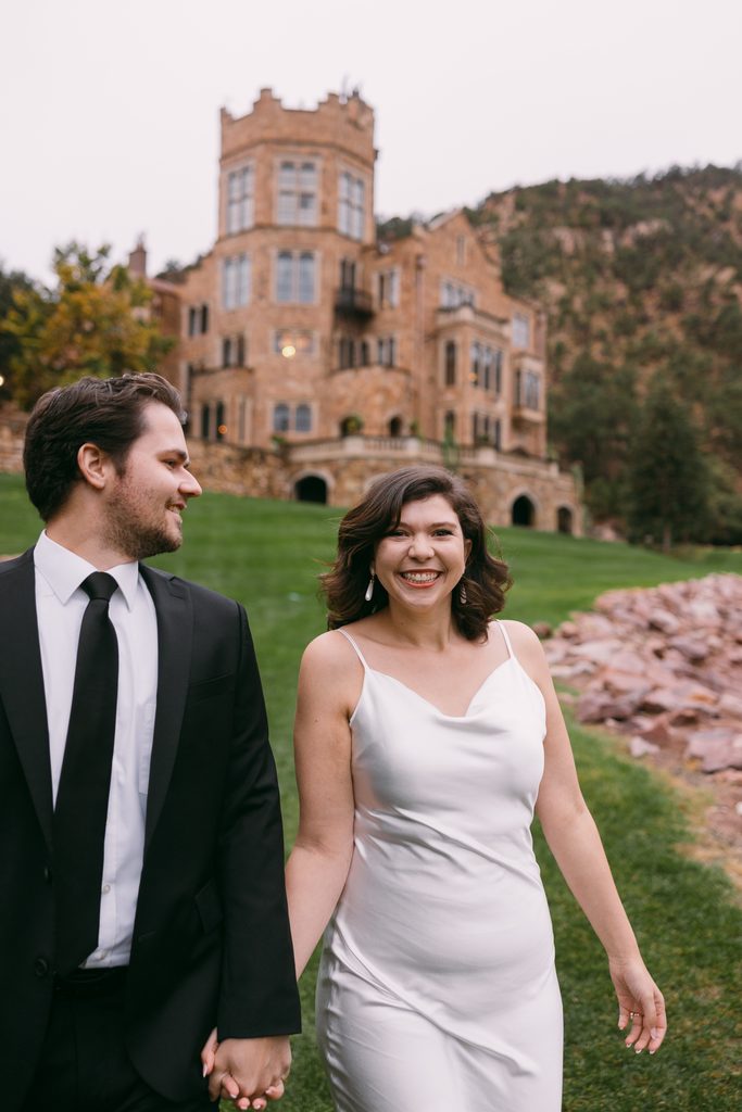 Bridgette smiles as she walks hand in hand with Logan across the green lawn