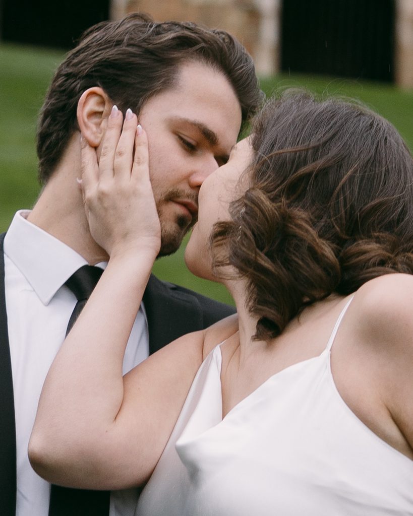 Close-up of Bridgette and Logan kissing, her hand resting on his cheek