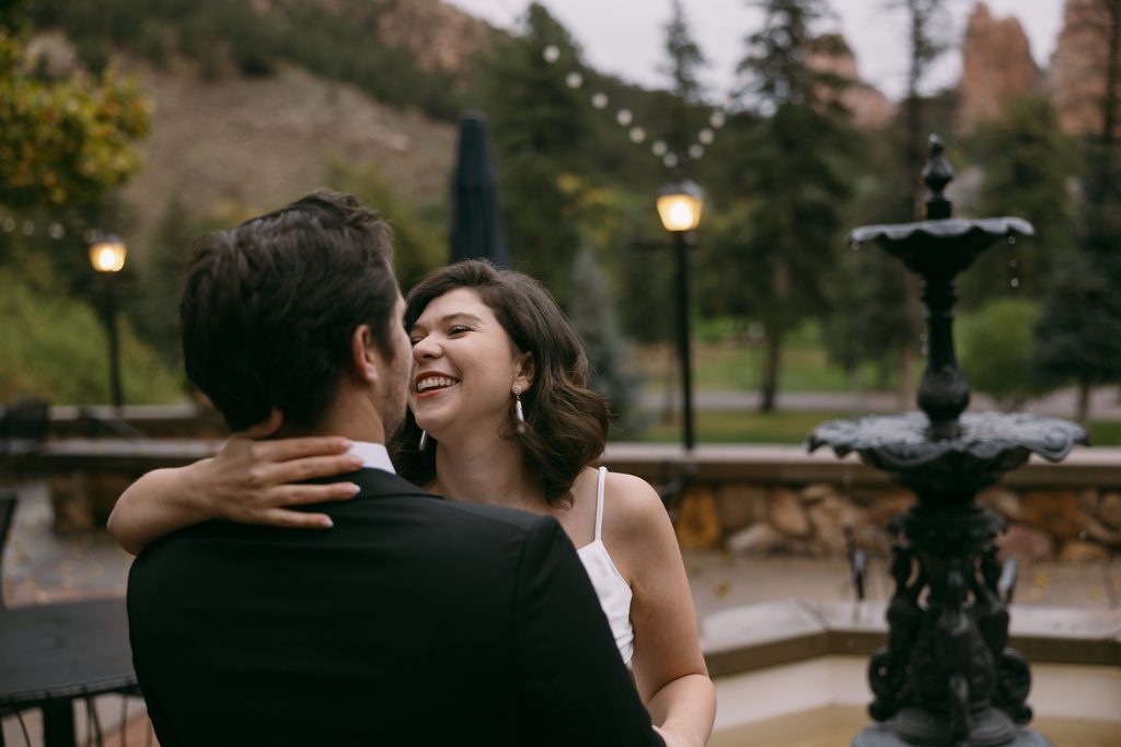Close embrace on the Glen Eyrie Castle patio beside the tiered iron fountain
