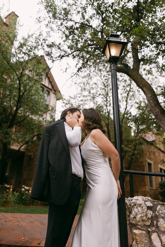 Bridgette and Logan kiss beside a vintage lamppost on the castle grounds